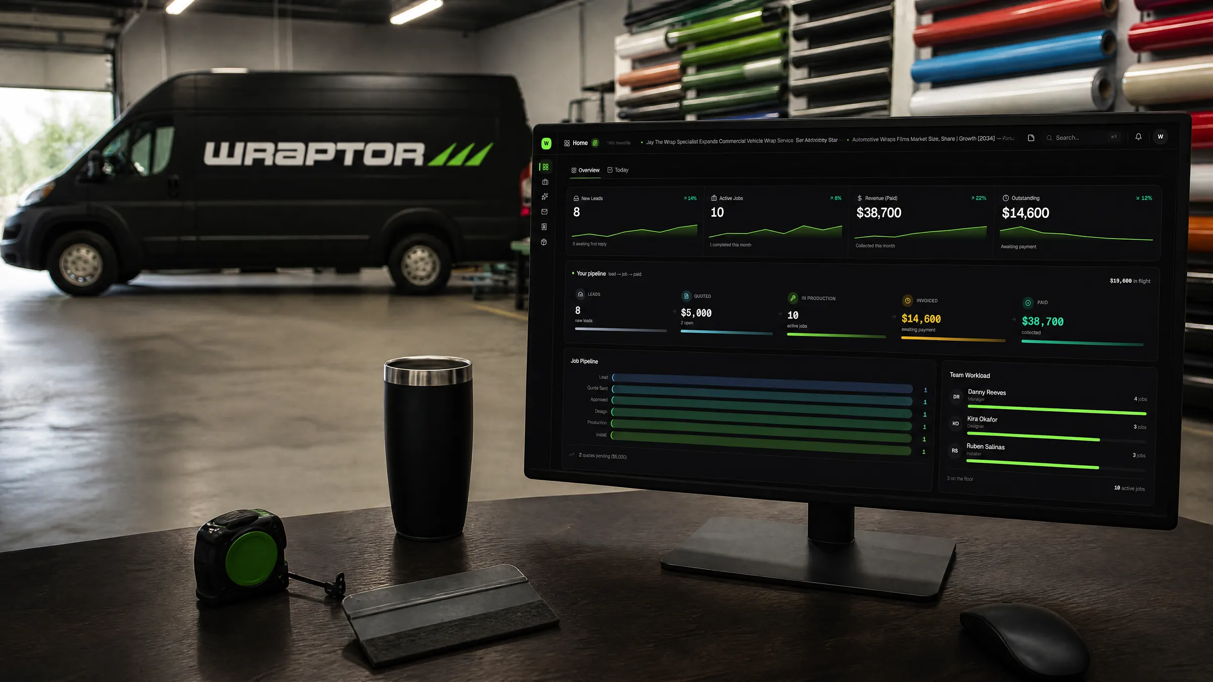 Wraptor on a shop owner's screen, with a wrapped van and vinyl rolls on the shop floor